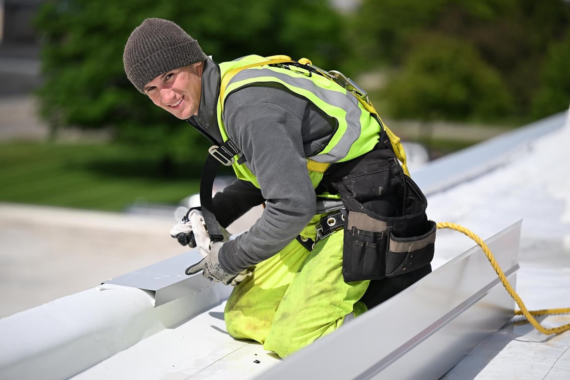 Green Improvements roofer securing metal flashing at a roof edge