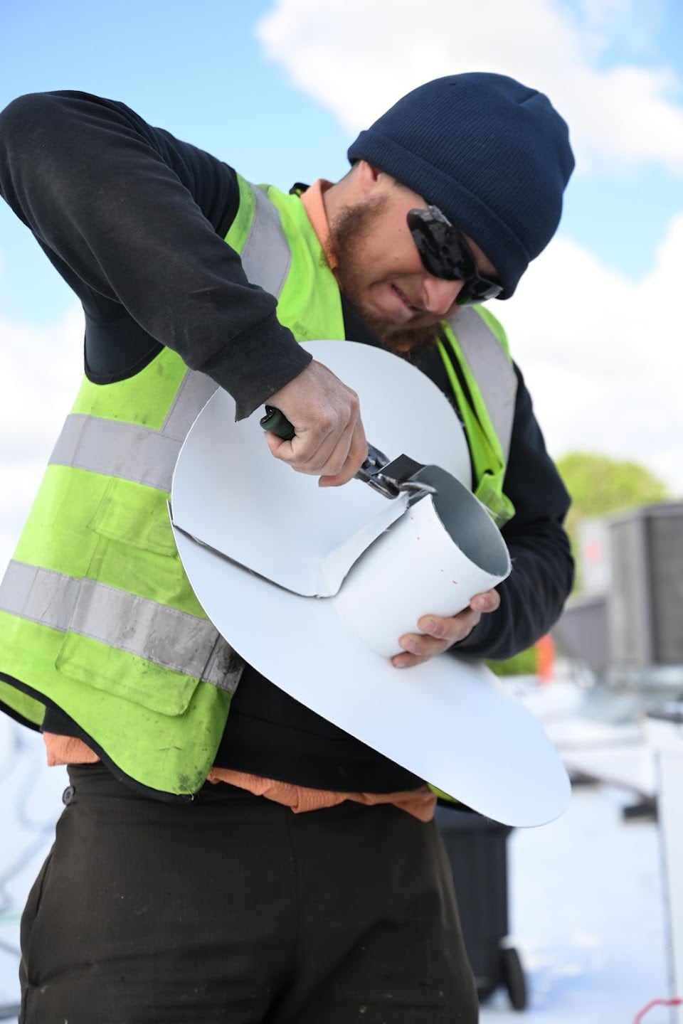Green Improvements roofer preparing a sheet of roofing membrane