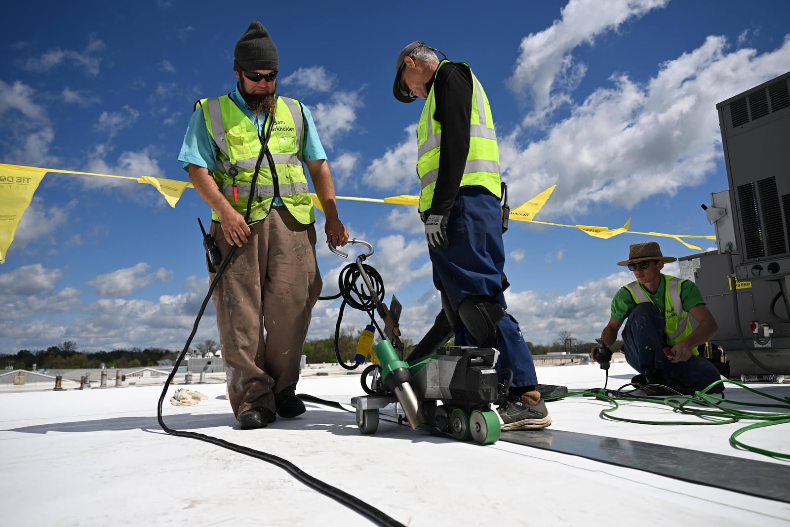 Green Improvements crew coordinating work around roofing equipment