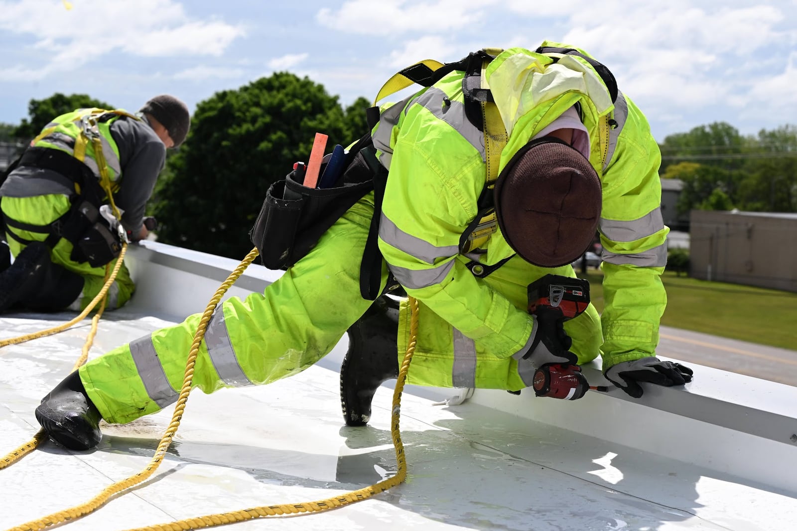 Green Improvements roofers working together along a commercial roof edge