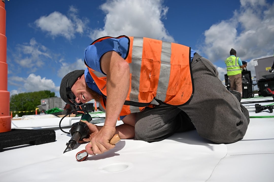 Green Improvements roofer heat-welding a seam on a commercial roof