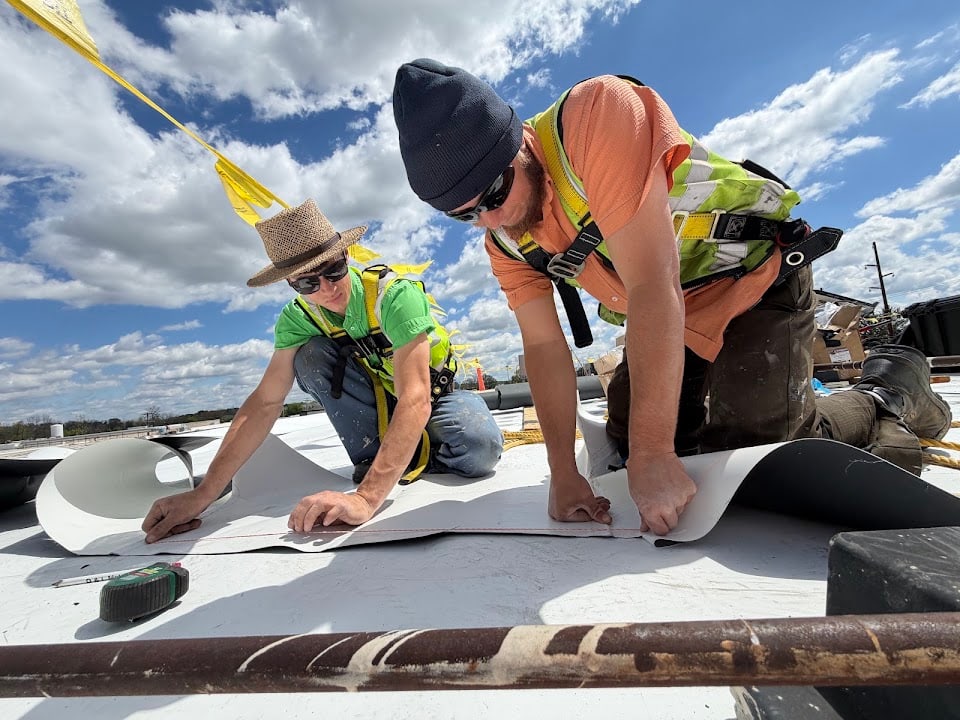 Green Improvements crew fitting membrane across a commercial roof