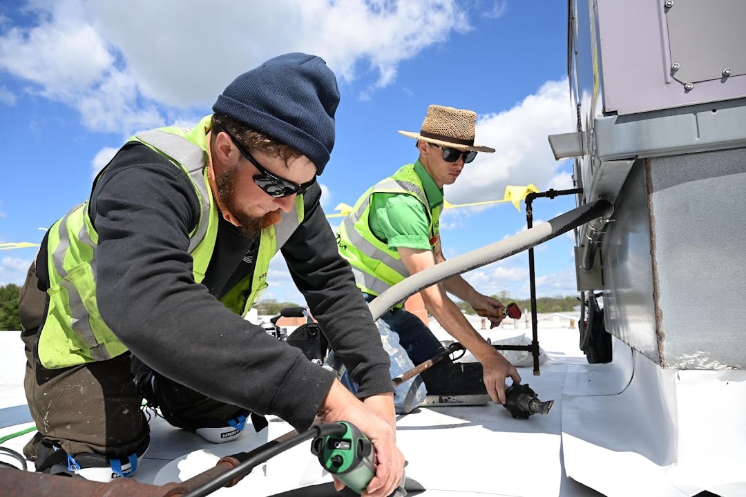 Green Improvements roofers working beside rooftop equipment